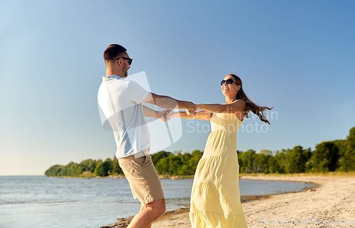 Image of happy couple holding hands on summer beach