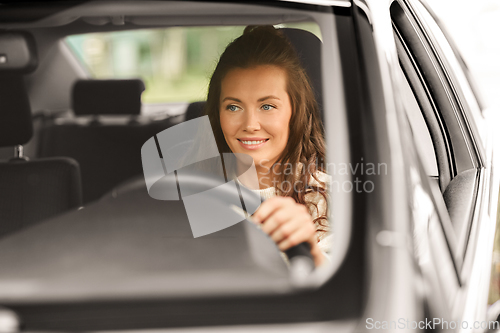 Image of woman or female driver driving car in city