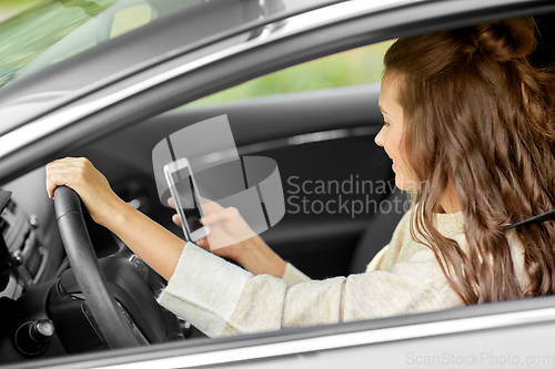 Image of smiling woman or female driver driving car in city