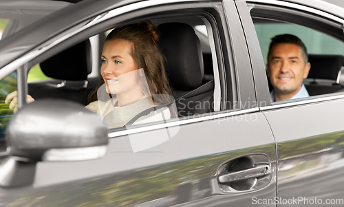 Image of female driver driving car with male passenger