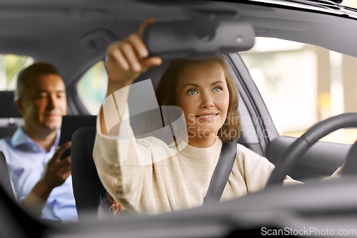 Image of female driver driving car with male passenger