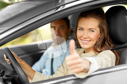 Image of car driving instructor and woman showing thumbs up