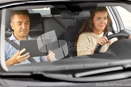 Image of woman and driving school instructor talking in car