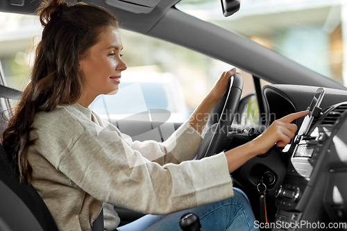 Image of smiling woman or female driver driving car in city