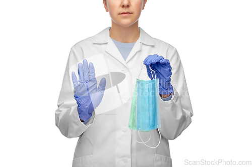 Image of female doctor with two masks showing stop gesture
