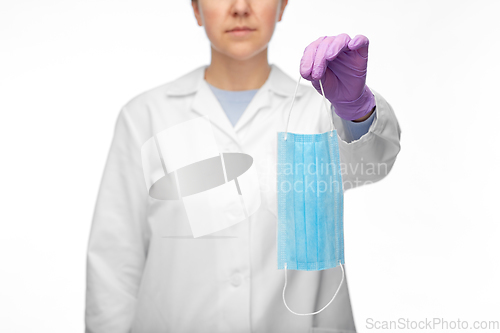 Image of female doctor in gloves showing medical mask