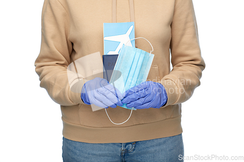 Image of woman with mask, passport and air ticket