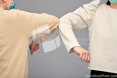 Image of close up of women making elbow bump gesture