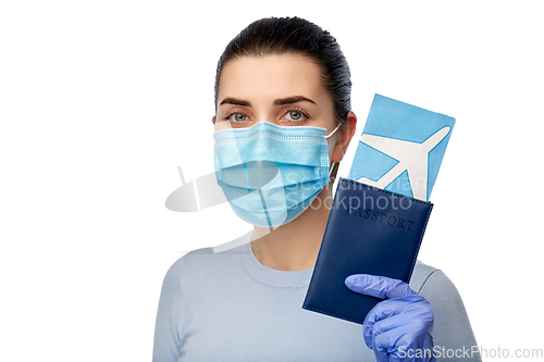 Image of young woman in mask with air ticket and passport