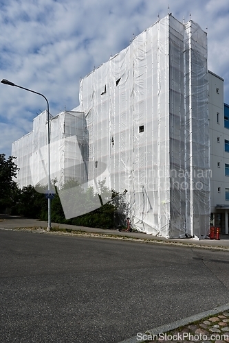 Image of Scaffold in front of building facade covered with fabric