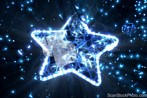 Image of Bright beautiful glowing star on a Christmas tree in the evening