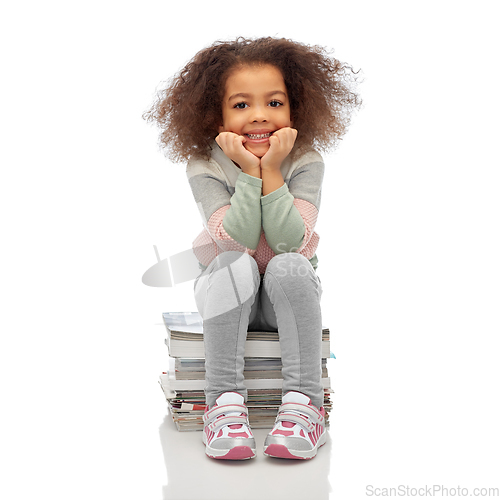 Image of smiling girl with magazines sorting paper waste