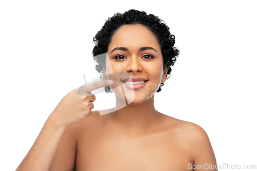 Image of young african american woman pointing to her mouth