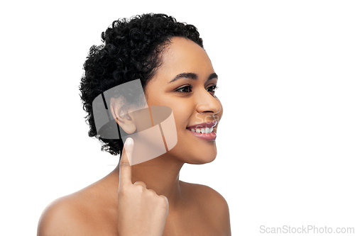 Image of smiling african american woman showing her ear