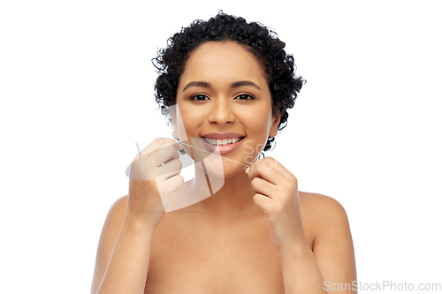 Image of african woman cleaning teeth with dental floss