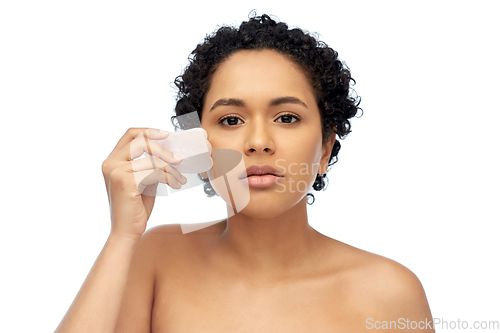 Image of young woman massaging her face with gua sha tool