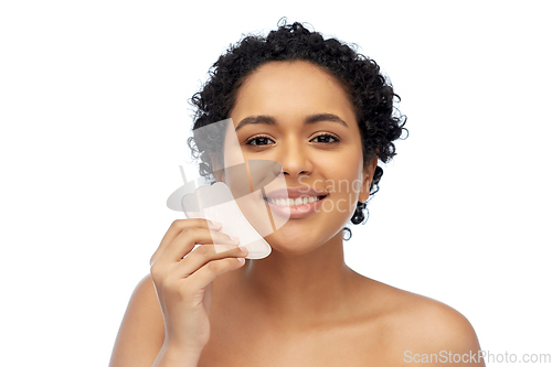 Image of happy woman massaging her face with gua sha tool