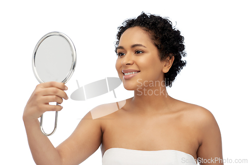 Image of smiling african american woman looking to mirror