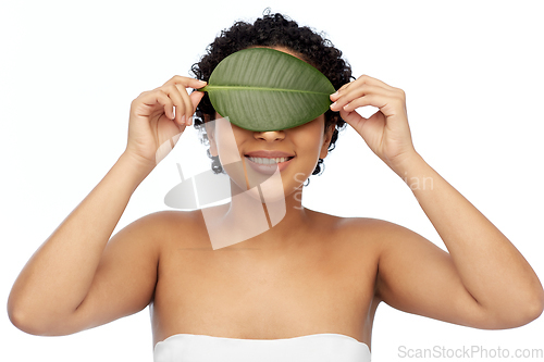 Image of portrait of african american woman with green leaf