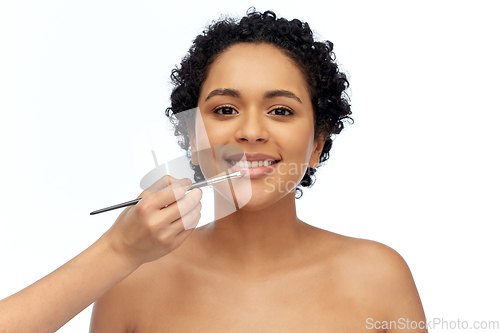 Image of happy woman and hand of make up artist with brush