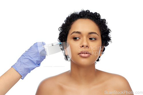 Image of face of african woman and hand with syringe