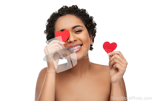 Image of african american woman covering eyes with hearts