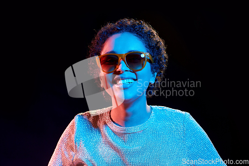 Image of african woman in sunglasses over neon lights