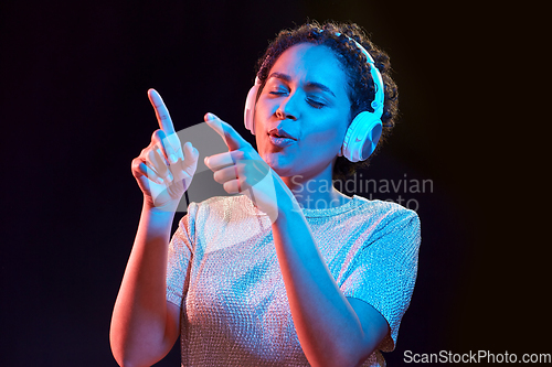 Image of woman in headphones listening to music and dancing