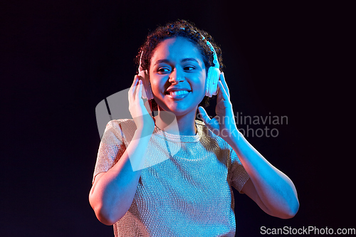 Image of woman in headphones listening to music and dancing