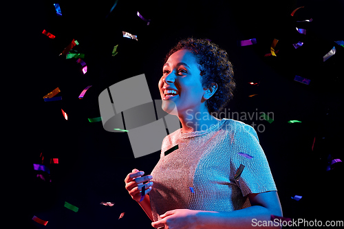 Image of african woman under confetti at nightclub party