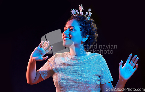 Image of african woman in party cap with blower over black