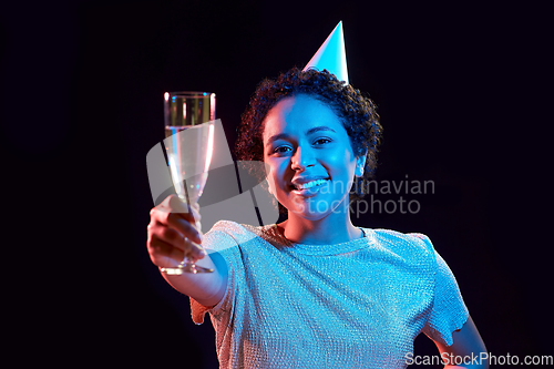 Image of african woman in party cap with glass of champagne