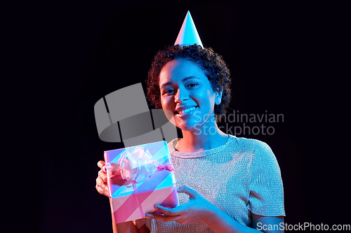 Image of african woman in party cap with gift box on black