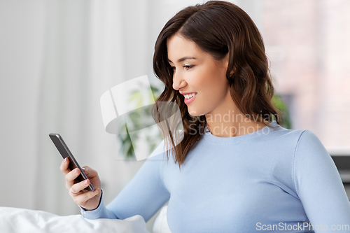 Image of woman with smartphone at home