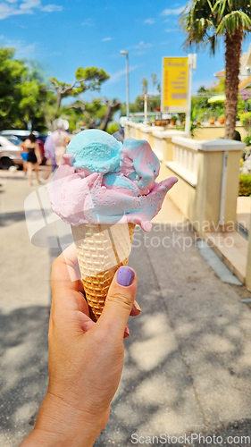 Image of Gelato ice cream cone held up to the hot summer city