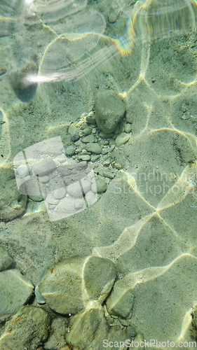 Image of Blurred abstract marine background, stones underwater. Clear sea water covers the rocks