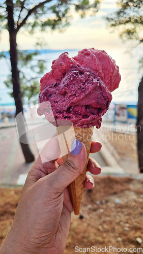 Image of Gelato ice cream cone held up to the hot summer city