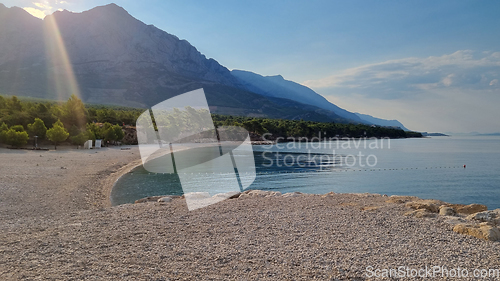 Image of Beautiful shore of the Adriatic Sea. Sunrise over Biokovo Mountain Nature park and trees from Makarska Riviera-Biokovo, Dalmatia, Croatia, Europe