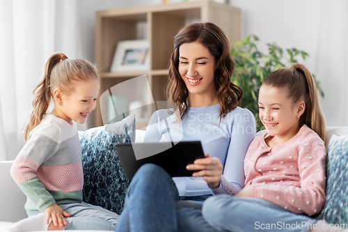 Image of happy mother and daughters with tablet pc at home