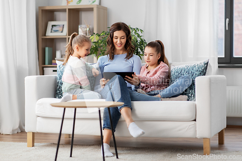 Image of happy mother and daughters with tablet pc at home