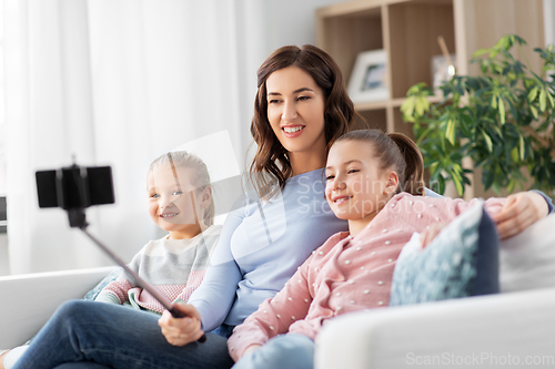 Image of happy family taking selfie by smartphone at home