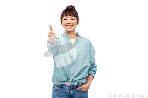 Image of happy asian woman showing thumbs up over white