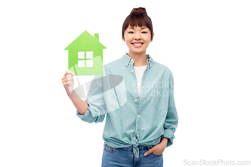 Image of smiling asian woman holding green house