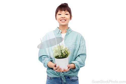 Image of happy smiling asian woman holding flower in pot