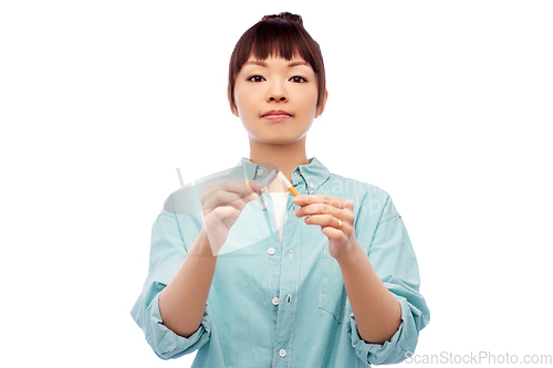 Image of asian woman braking cigarette over white background