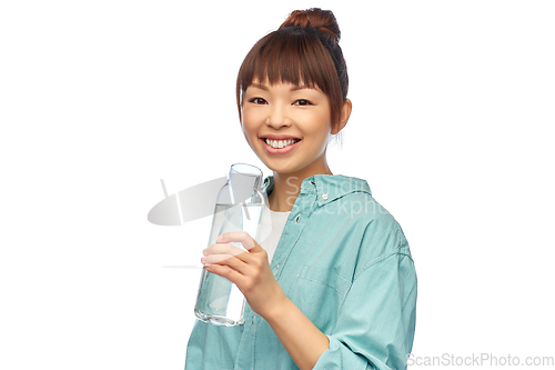 Image of happy asian woman holding glass bottle with water