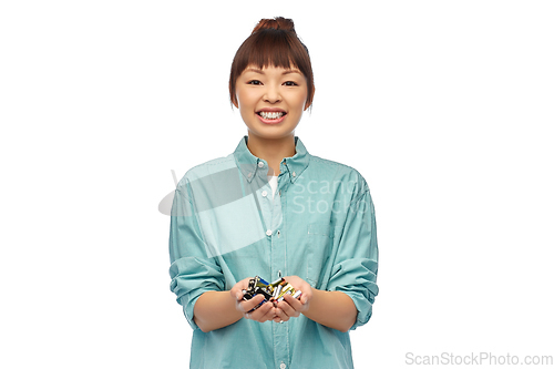 Image of smiling young asian woman with alkaline batteries