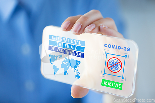 Image of hand with certificate of vaccination on smartphone