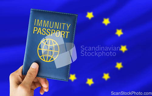 Image of hand holding immunity passport over european union