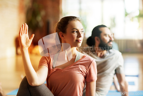 Image of woman with group of people doing yoga at studio